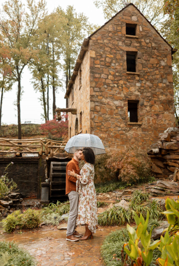 couple standing in the rain under umbrella
