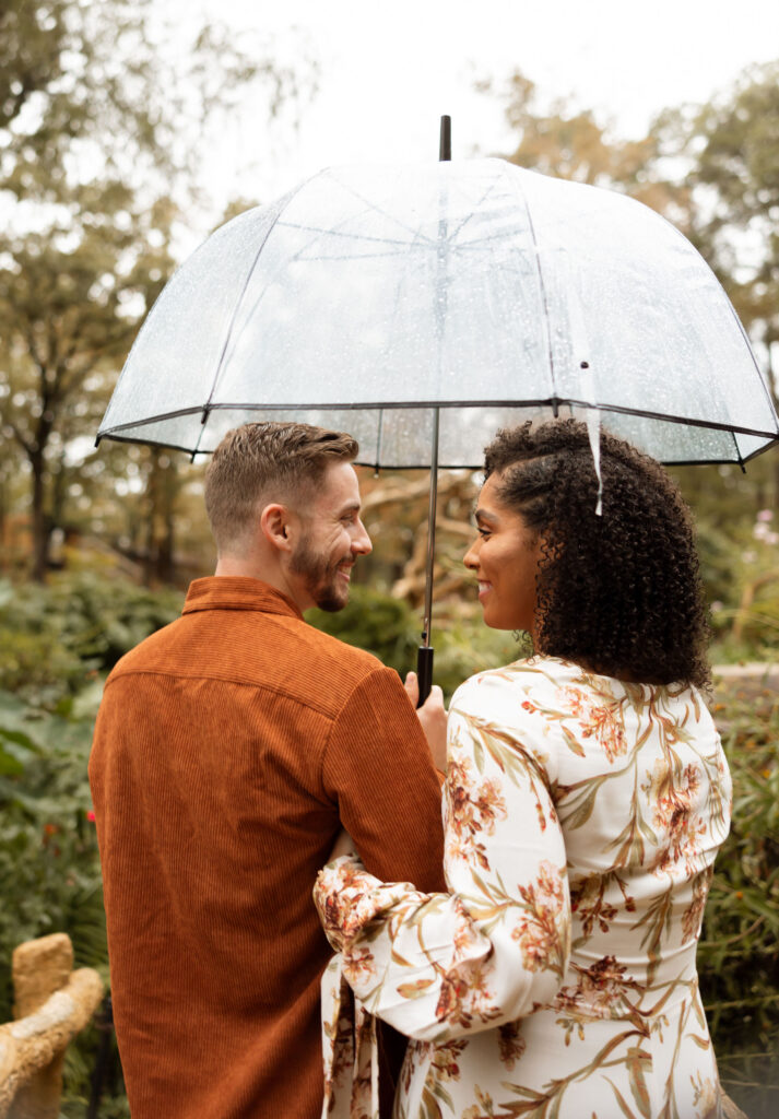 couple standing in the rain under umbrella