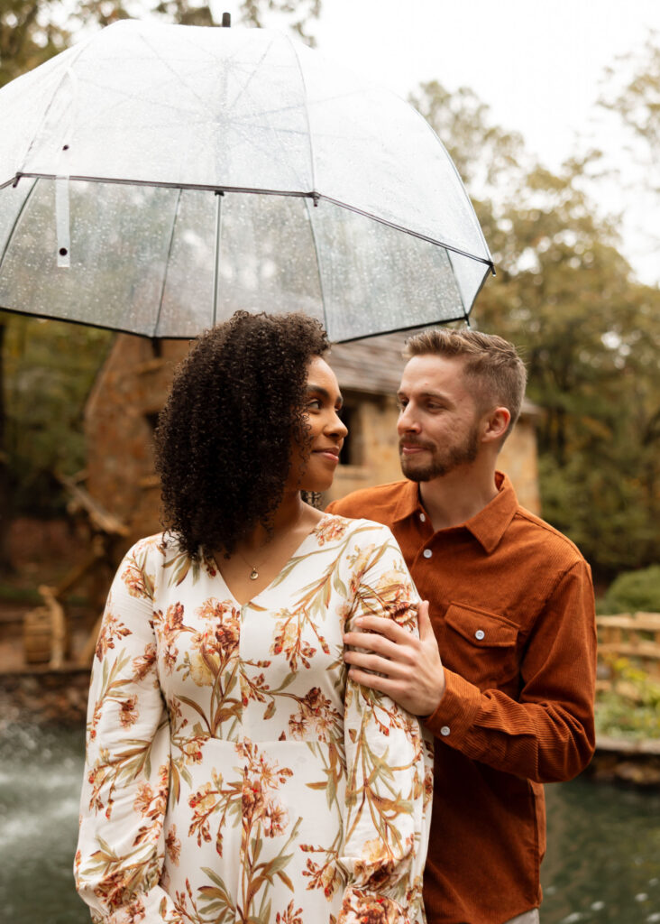 couple standing in the rain under umbrella