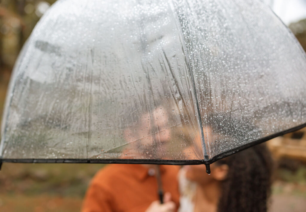 couple smiling under umbrella