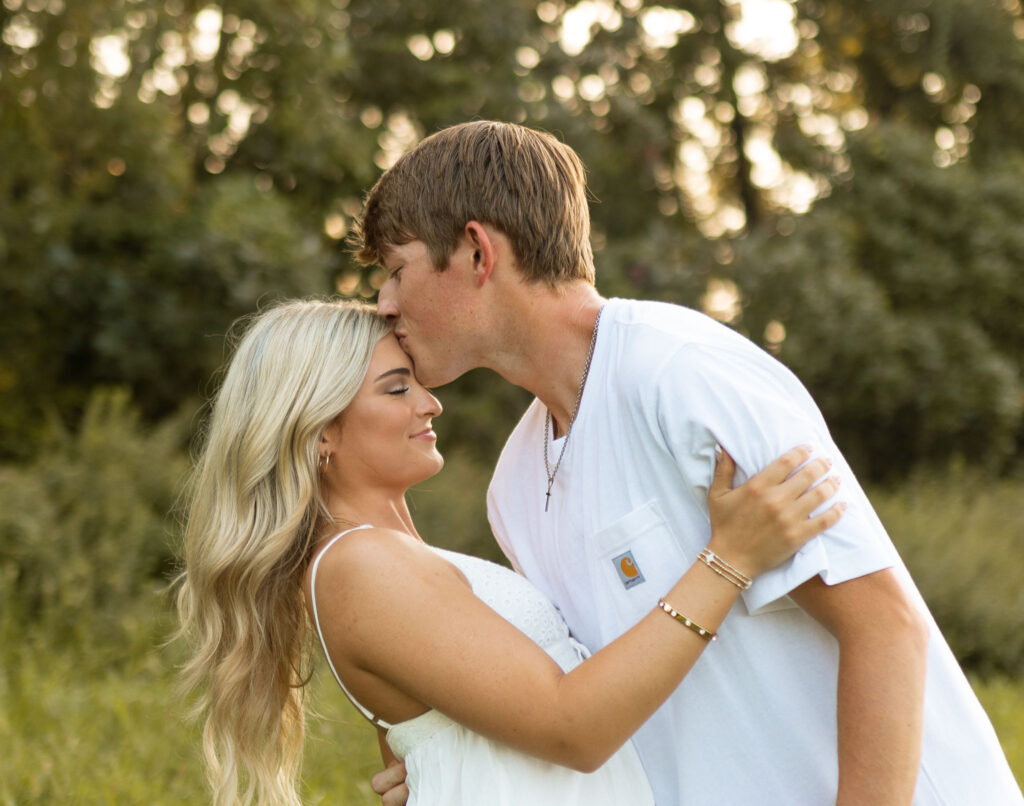 romantic couples poses with cowboy boots in a field