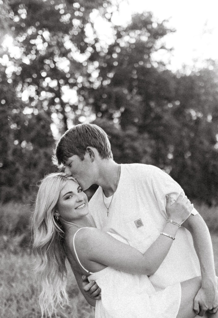 romantic couples poses with cowboy boots in a field