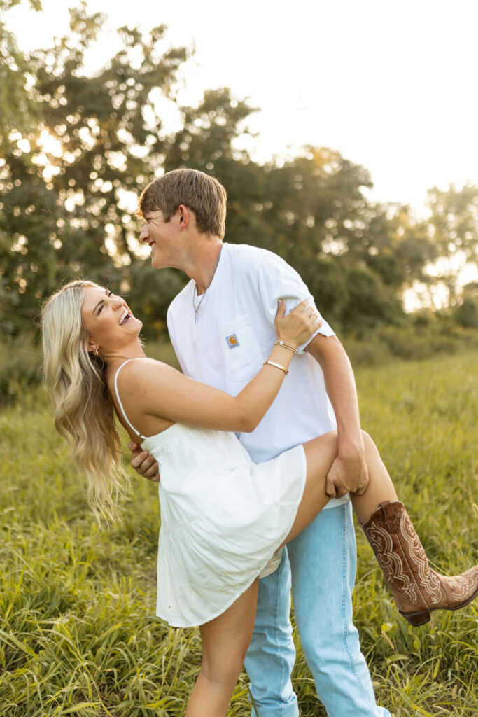 romantic couples poses with cowboy boots in a field