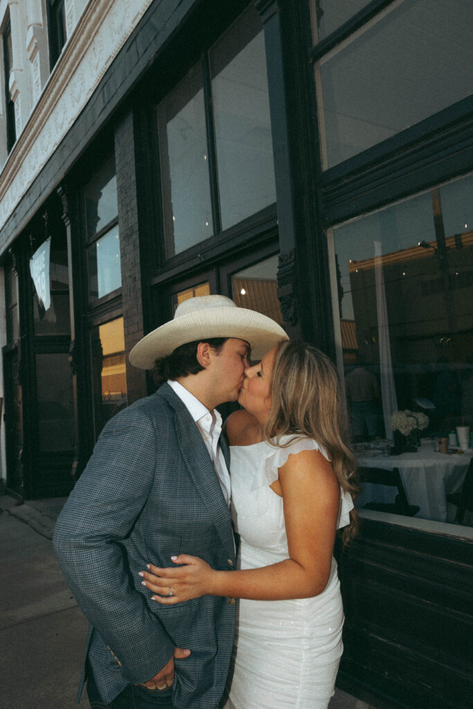 bride and groom kissing outside wedding venue in arkansas