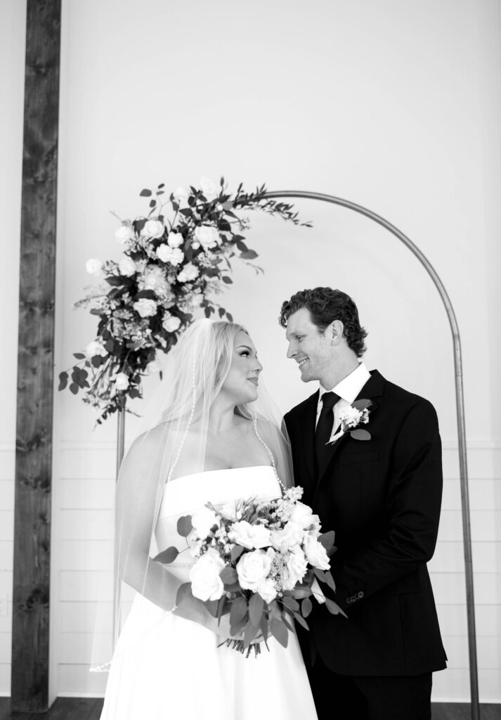 bridal portraits with bride and groom wedding arch with flowers