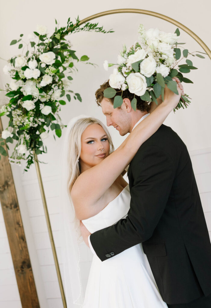 bridal portraits with bride and groom wedding arch with flowers