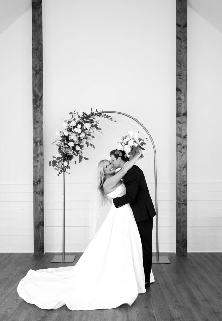 bridal portraits with bride and groom wedding arch with flowers