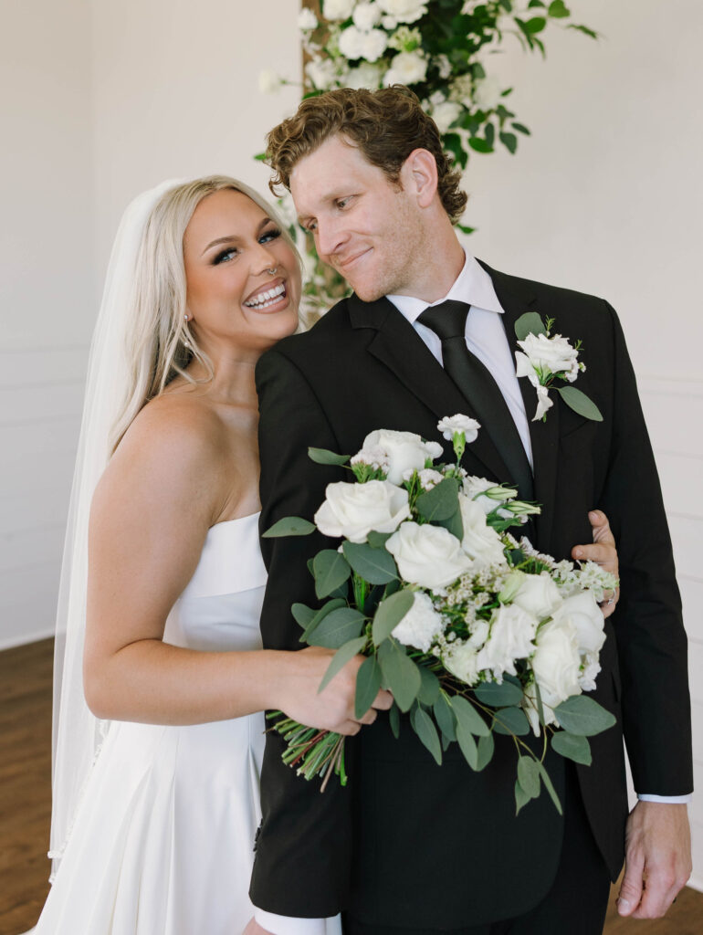 bridal portraits with bride and groom wedding arch with flowers