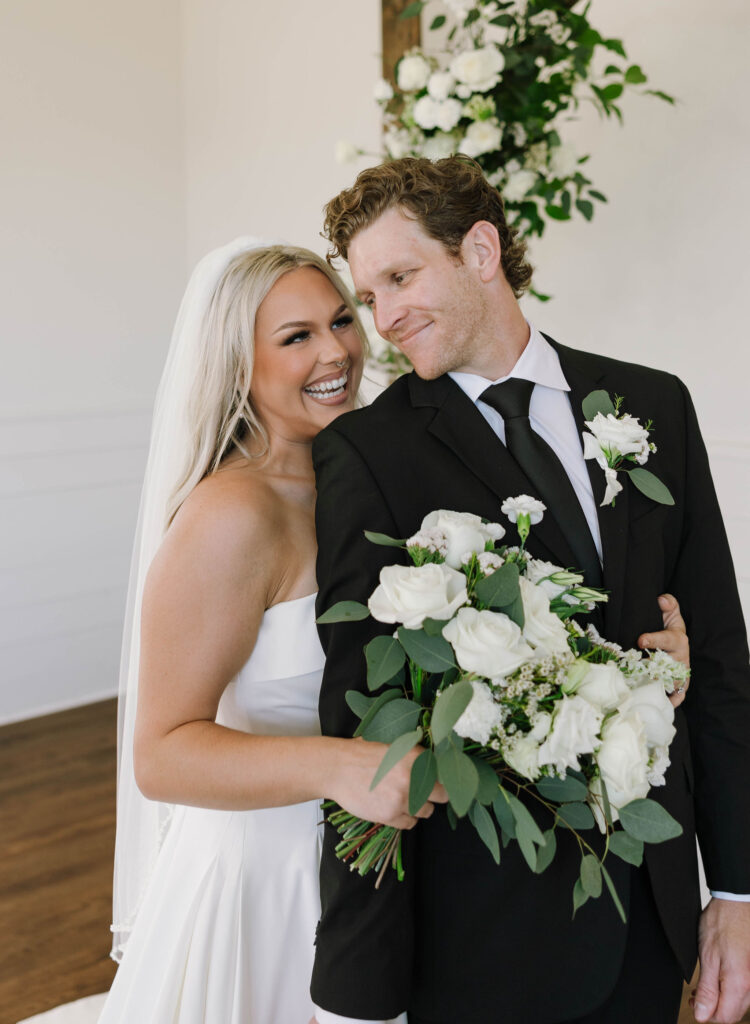 bridal portraits with bride and groom wedding arch with flowers