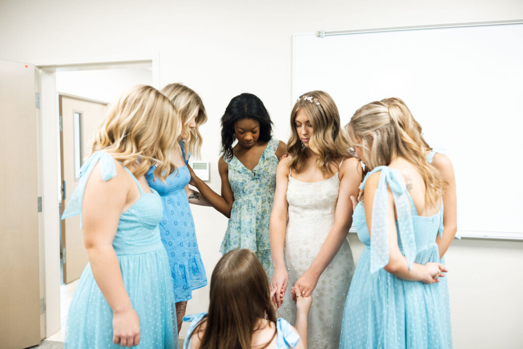 bridesmaids praying over bride before ceremony